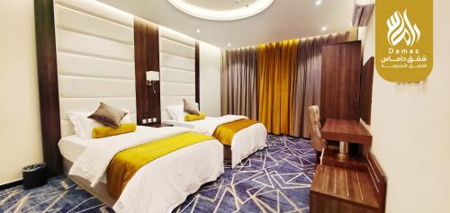 a hotel room with two beds in a room at داماس للأجنحة الفندقية Damas Hotel Suites in Al Maraghah