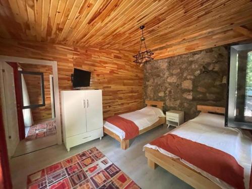 a bedroom with two beds in a log cabin at Ece Hanı Bungalow Hotel in Yaka