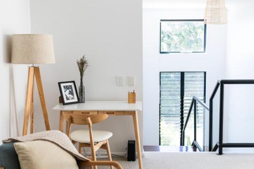 a living room with a table and a chair at Papillon Coolum in Coolum Beach