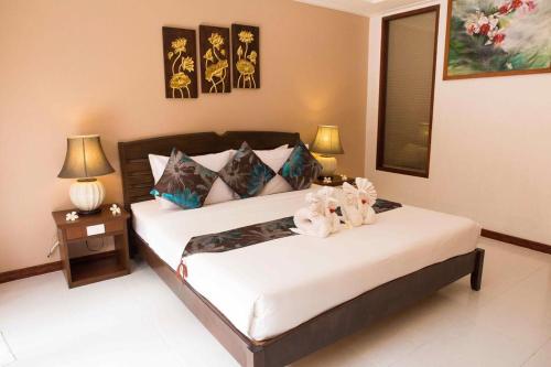 a bedroom with a bed with two lamps and two tables at The Florist Resort in Mae Nam