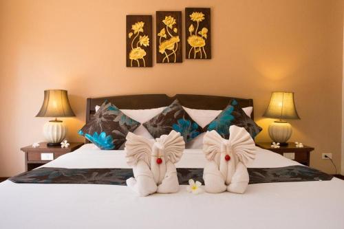 a bedroom with a bed with two towels on it at The Florist Resort in Mae Nam