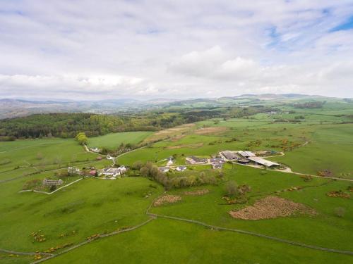 an aerial view of a house in a green field at Middle Byre at Clauchan Holiday Cottages in Gatehouse of Fleet