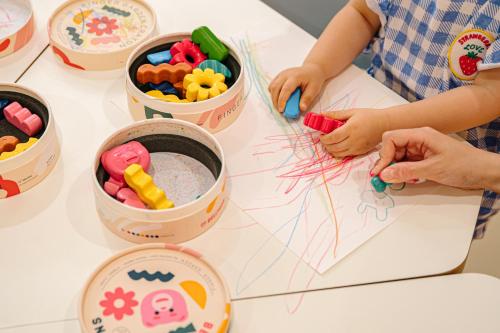 a group of children sitting at a table with buckets of toys at Lotte Hotel World in Seoul