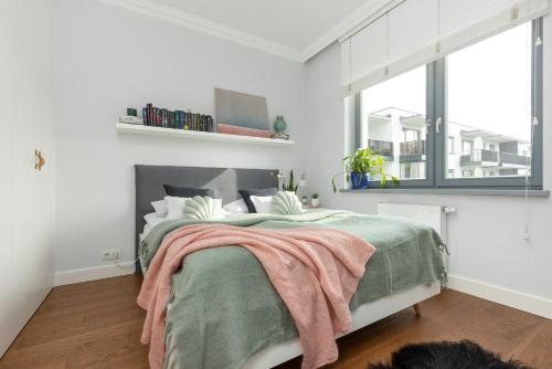 a white bedroom with a bed and a fireplace at Cozy Apartment Gieysztora Wilanów by Renters in Warsaw