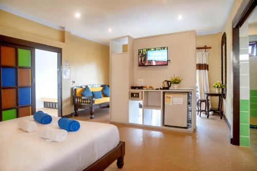 a bedroom with a bed and a kitchen and a living room at The Florist Resort in Mae Nam