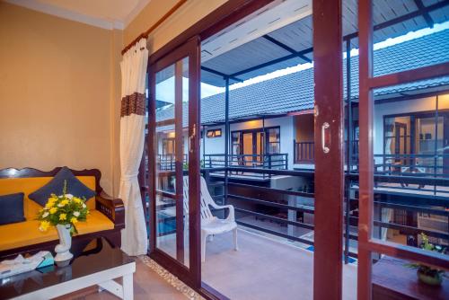 a room with a desk and a chair and a balcony at The Florist Resort in Mae Nam