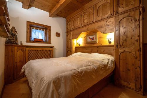 1 dormitorio con 1 cama con pared de madera en Casa Lacedel 1, on ski slopes en Cortina dʼAmpezzo