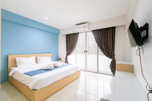 a bedroom with a large bed with a tv on it at Ruan Plaisoi Apartment in Bangkok