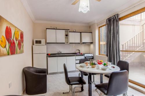 a kitchen and dining room with a table and chairs at Pool & Sea Merill Apartments Mellieha in Mellieħa