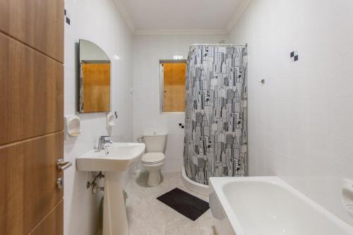 a bathroom with a sink toilet and a shower curtain at Pool & Sea Merill Apartments Mellieha in Mellieħa