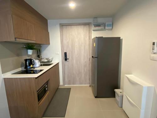 a small kitchen with a refrigerator and a sink at A luxurious and romantic at Lacasita Huahin by Pikul in Hua Hin
