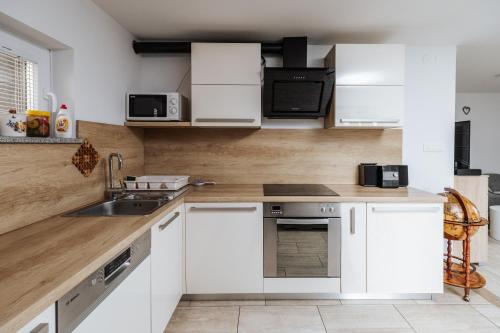 a kitchen with white cabinets and a sink at Tanja s Holiday Home in Nature with sauna and hot tub in Gorica pri Slivnici