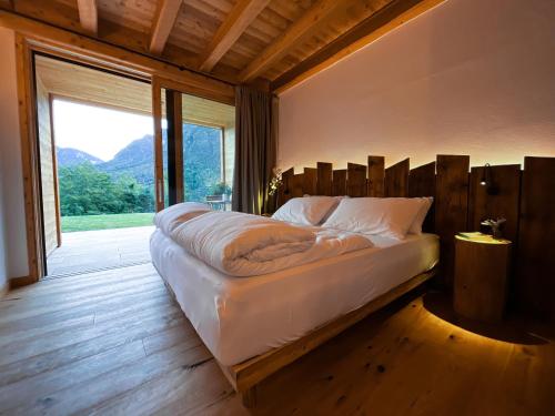 a large bed in a room with a large window at Agritur Maso Il Gioco in Balbido-rango