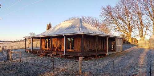 a small wooden house in a field with a fence at Chandlers Rest in Neville