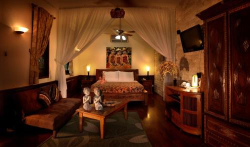 a bedroom with a bed and a couch and a table at Tempat Senang Spa Resort & Restaurant in Sekupang