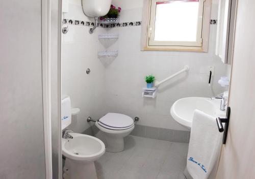 bagno bianco con servizi igienici e lavandino di Dimora Dei Turchesi a Gagliano del Capo