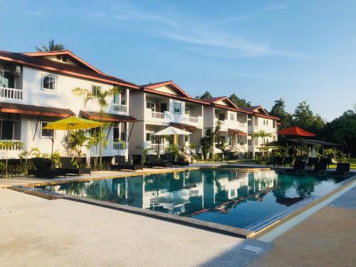 a swimming pool in front of some buildings at Maikhao Beach Residence in Mai Khao Beach