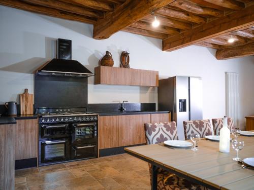 une cuisine avec une table et une cuisinière four supérieur dans l'établissement Le Vignoble, à Roquemaure