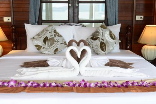 two swans made out of towels on a bed at The Florist Resort in Mae Nam
