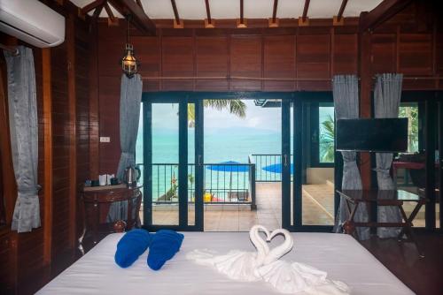 a bedroom with a bed with a swan decoration on it at The Florist Resort in Mae Nam