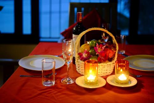 a table with a basket of fruit and a bottle of wine at The Florist Resort in Mae Nam