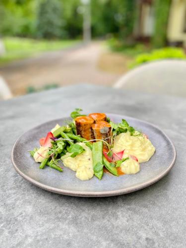 a plate of food with a salad on a table at Villa Hotel in Debrecen
