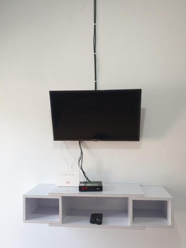 un centro de entretenimiento blanco con TV de pantalla plana en la parte superior en BTN Mahkota Pemenang 13 Tamarin 3A en Pawenang