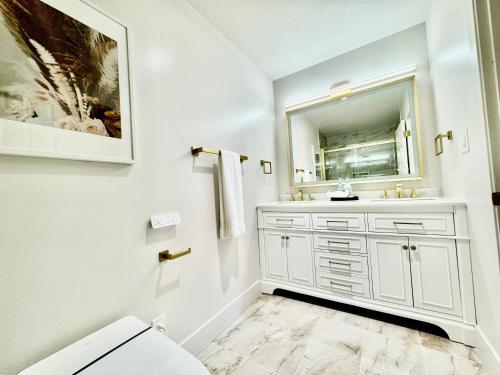 a white bathroom with a sink and a mirror at Stunning apartment steps from Ocean Beach in San Francisco