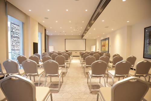 a conference room with chairs and a projection screen at The Abdali Boulevard Hotel in Amman