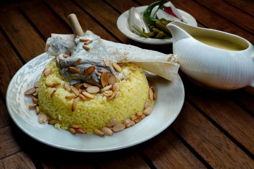a plate of food with nuts on top of rice at The Abdali Boulevard Hotel in Amman