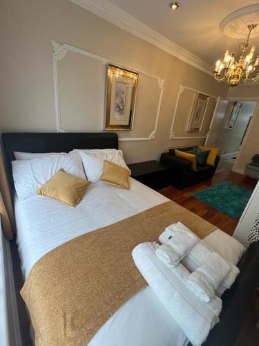 a bedroom with a large bed with towels on it at JAN'S HAVEN Wembley Park - lovely 1 bedroom flat, sleeps 4, free parking, 10 minutes from Wembley stadium and Wembley Park station in London