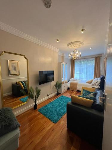 a living room with a couch and a large mirror at JAN'S HAVEN Wembley Park - lovely 1 bedroom flat, sleeps 4, free parking, 10 minutes from Wembley stadium and Wembley Park station in London