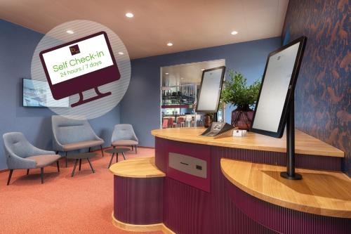 una sala d'attesa con una scrivania con un computer sopra di b-smart hotel Arbon ad Arbon