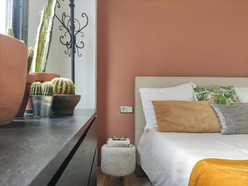 een slaapkamer met oranje muren en een bed en een cactus bij Refugio Racó del Conill - Mountain, Beach & Spa in Benidorm