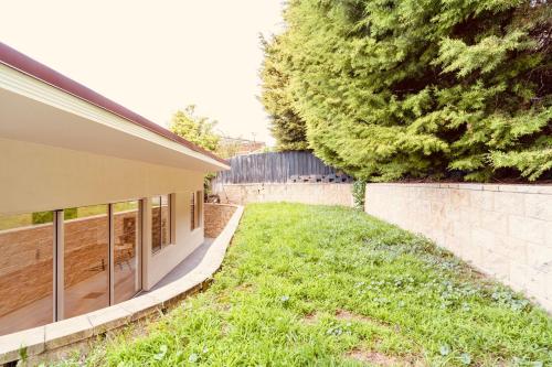 a house with a yard next to a wall at Spacious 3 bedrooms family living in Rosetta in Rosetta