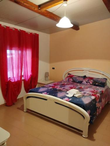 - une chambre avec un lit et des rideaux rouges dans l'établissement Appartamento mare, à Siderno Marina