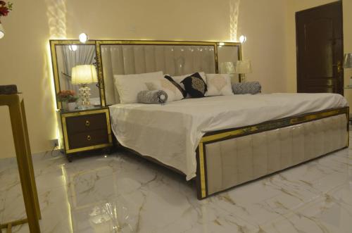 a bedroom with a large bed with a marble floor at Charming Home banglow in Karachi