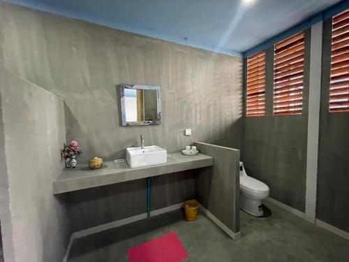 uma casa de banho com um lavatório e um WC em Blue Indigo yoga Cambodia em Phnom Penh