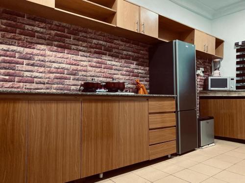 a kitchen with a brick wall and a refrigerator at Zenith abode in Abuja
