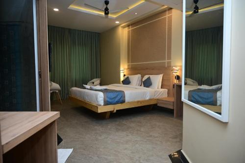 a hotel room with two beds and a mirror at Pipul Ocean View Resort in Puri