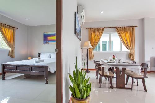 a bedroom and dining room with a bed and a table at Maikhao Beach Residence in Mai Khao Beach