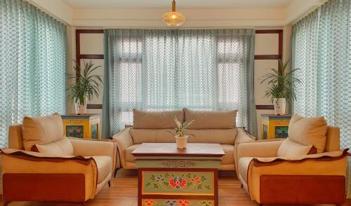 a living room with a couch and chairs and a table at Voyage Glenz Resort in Pakyong