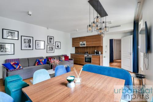 - une salle à manger et un salon avec une table et des chaises bleues dans l'établissement Urban Flat 75 - Sublime 3BDR Flat near Les Jardins du Luxembourg, à Paris