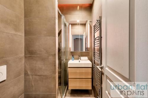 une salle de bain avec un lavabo et une douche dans l'établissement Urban Flat 75 - Sublime 3BDR Flat near Les Jardins du Luxembourg, à Paris