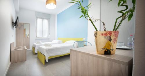 1 dormitorio con 1 cama y un jarrón con una planta en b&b Amaca, en Pavia