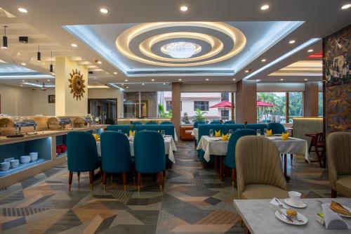 a restaurant with blue chairs and tables and a bar at The Avenue Grand in Calangute