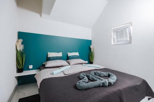 a bedroom with two beds and a blue wall at Tanja s Holiday Home in Nature with sauna and hot tub in Gorica pri Slivnici