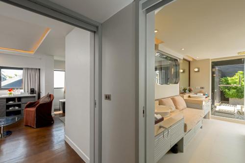 a bathroom with a sink and a living room at The Boathouse Phuket-SHA Plus in Kata Beach