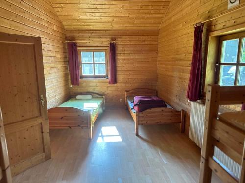 um quarto com 2 camas num chalé de madeira em Achtsamkeit - b43232 em Losheim