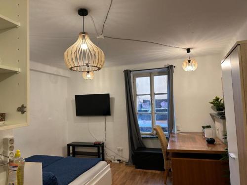 ein Schlafzimmer mit Bett, Schreibtisch und Fenster in der Unterkunft Trier City Center Apartments Altstadt in Trier